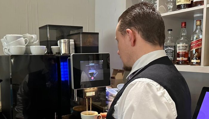 Man filling coffee cup from machine